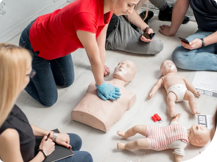 A group of people practicing cpr on dummies.